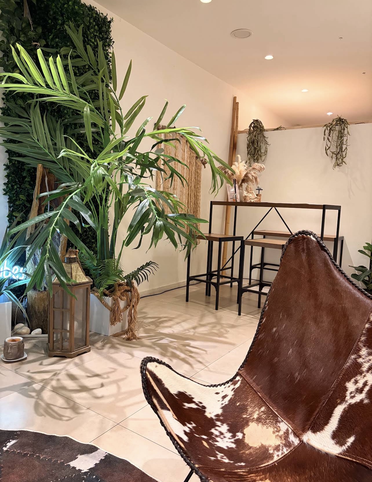Plant-filled lounge and reception corner at The Moment Massage Boutique